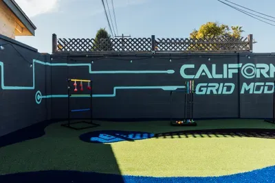 Outdoor game space with turf and interactive setups, perfect for fun activities and entertainment in the backyard.