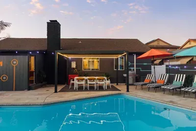 Private backyard pool with lounge chairs, shaded dining pergola, and BBQ grill—perfect for relaxing or entertaining.