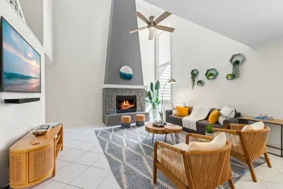 A bright and inviting living area featuring a fireplace and warm coastal design elements.