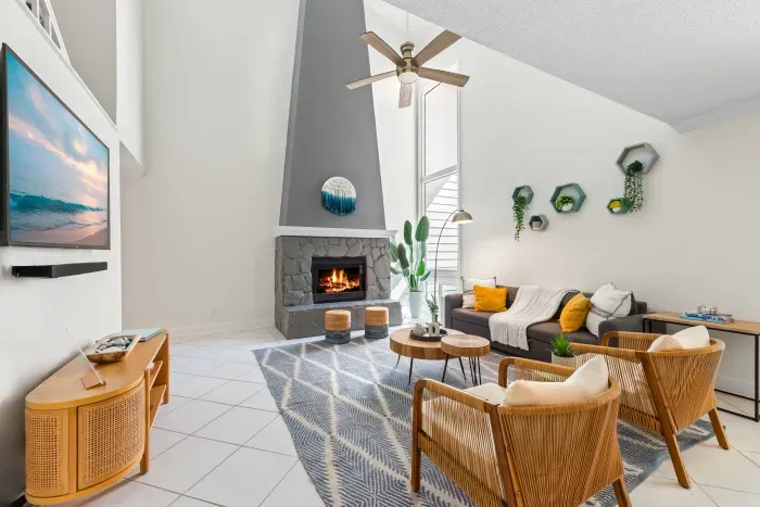 A bright and inviting living area featuring a fireplace and warm coastal design elements.