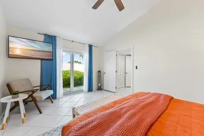 Bright and spacious ensuite bedroom with warm coastal décor, cozy finishes, and a private bathroom for easy, comfortable access.