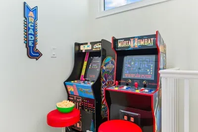 Level up the fun! ✨ This cozy loft space is packed with excitement, featuring two sit-down arcade games for endless hours of play. Perfect for kids and adults alike!