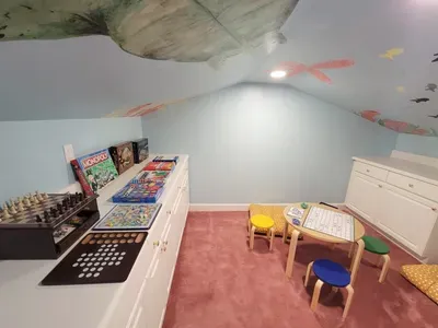 An under-the-sea inspired kids’ playroom featuring a ceiling mural, board games, and a cozy table for creative time and family moments.