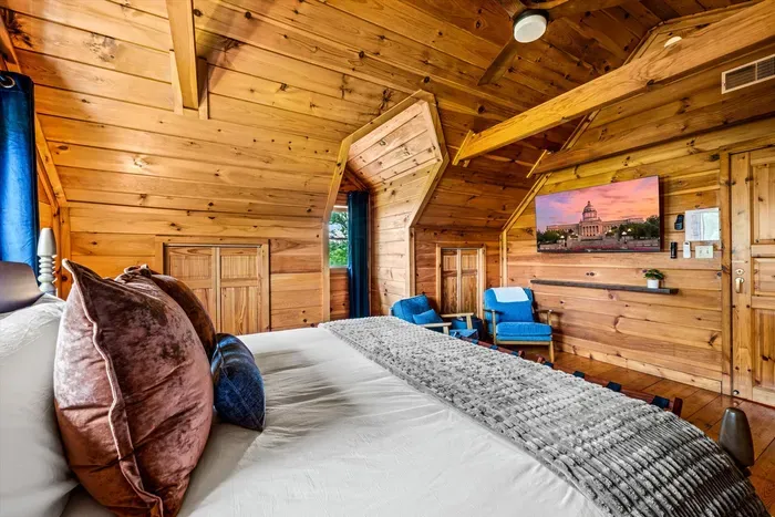 Second-floor king bedroom with a seating area and Roku TV.