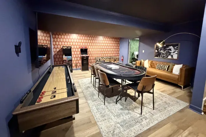 The basement game room features shuffleboard, arcade games, poker, and foosball.