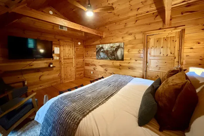 Second-floor king bedroom with a seating area and Roku TV.