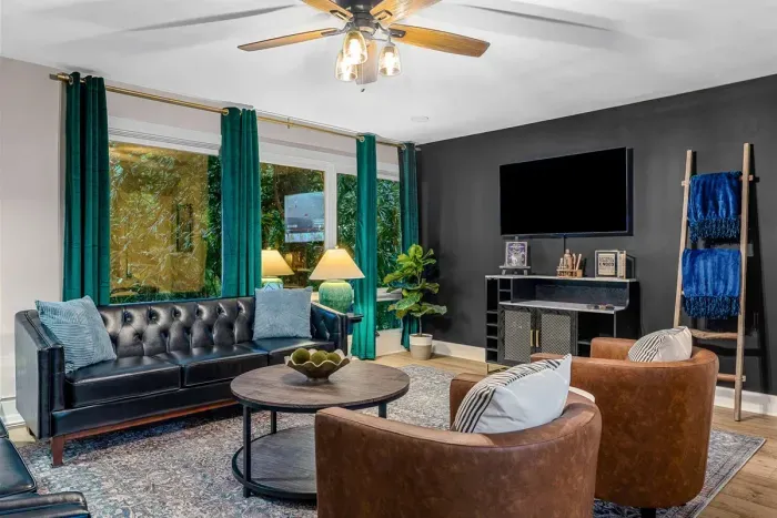 The living room has a bar equipped with bourbon glasses and wine glasses along with a cocktail book