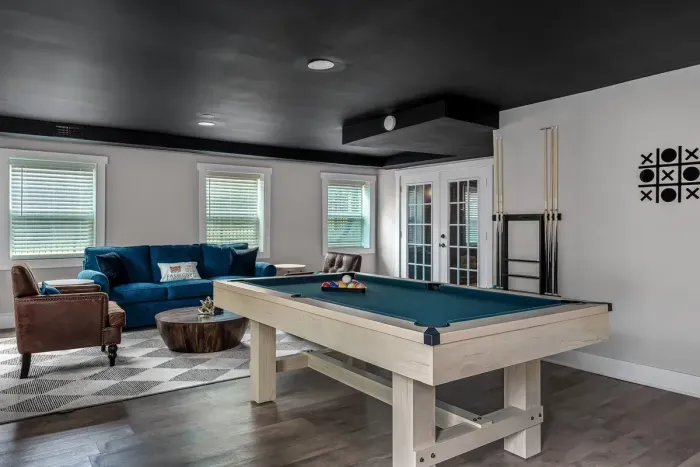 The game room is fully equipped with a pool table, shuffleboard, board games and other fun activities