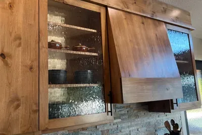 This home was completely remodeled, down to the studs, allowing us to design a kitchen that truly goes with the lake outside. The water-glass used on the kitchen cabinets, front door and lighting gives a wink and a knod to the water landscape.