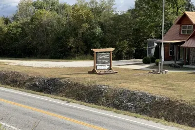 Spacious drive provides parking for multiple cars and allows for a vehicle to pull up right next to the drive way, providing easy access to the sloping sidewalk.