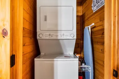 Stacked washer and dryer in one of the primary closets with starter laundry pods.