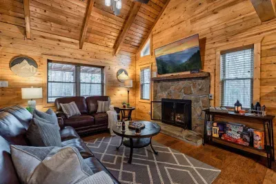 The dazzling living room offers luxury couches, a 65 inch tv and board games.