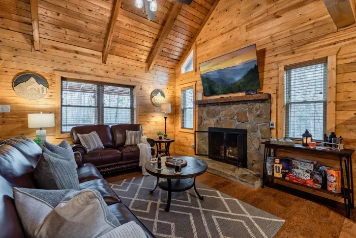 The dazzling living room offers luxury couches, a 65 inch tv and board games.