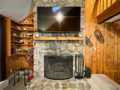 Cozy living room with a huge TV and an indoor fireplace
