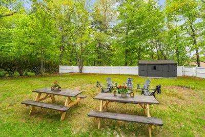 Spacious backyard with picnic tables and Adirondack chairs — perfect for outdoor dining and gatherings