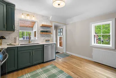 Modern green kitchen with brass accents and warm wood touches — perfect for home-cooked meals