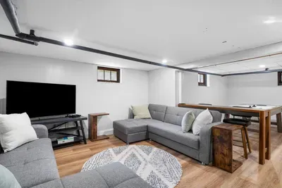 Downstairs, the second living space transforms into a game room hangout zone, great for kids or late-night board games.