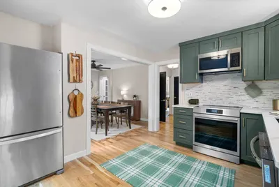 Modern green kitchen with brass accents and warm wood touches — perfect for home-cooked meals