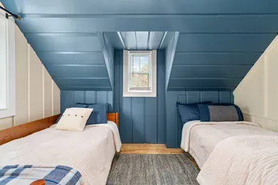 Upstairs, there’s a queen bedroom, plus a large bunk-style room with six twin beds, including two trundles—a dream setup for kids, cousins, and sleepovers.