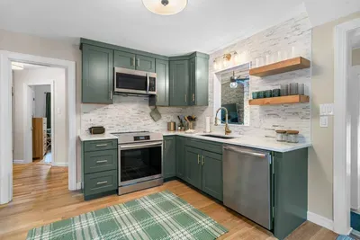 Modern green kitchen with brass accents and warm wood touches — perfect for home-cooked meals