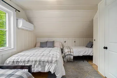 Upstairs, there’s a queen bedroom, plus a large bunk-style room with six twin beds, including two trundles—a dream setup for kids, cousins, and sleepovers.