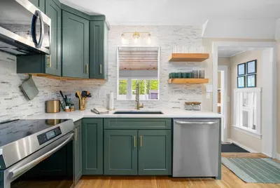 Modern green kitchen with brass accents and warm wood touches — perfect for home-cooked meals