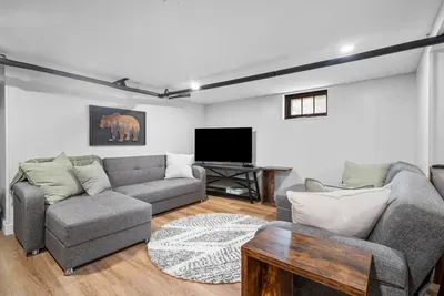 Downstairs, the second living space transforms into a game room hangout zone, great for kids or late-night board games.