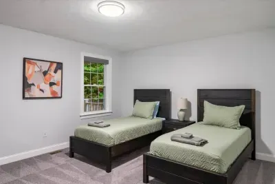 This view overlooks the porch. Cozy room with 2 comfy single beds—perfect for friends, families, or ski travelers. Warm lighting, soft linens, and a peaceful setup for a restful stay after skiing, holiday adventures, or snowy mountain escapes.