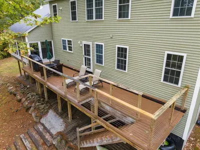 Relax on this peaceful winter deck surrounded by tall trees, complete with a BBQ grill, outdoor dining, and a cozy hangout space—perfect for skiers, families, and couples to unwind after a snowy day in the mountains.