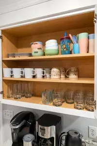 Cabinets fully stocked with mugs, glasses, kids’ dishes, and more.