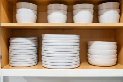 Fully stocked cabinet with dinnerware for the whole group.