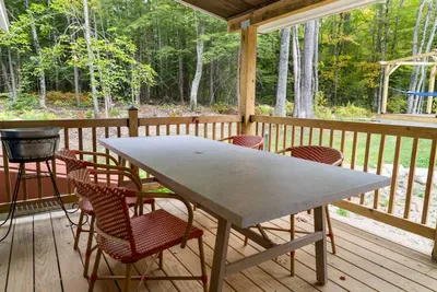 Covered deck with outdoor dining set.