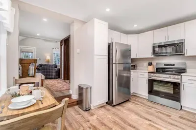 Full kitchen and a coffee table for two by the window.