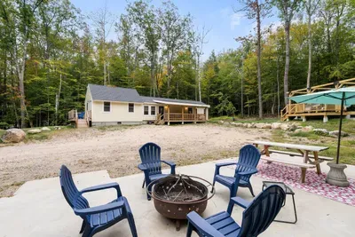 Spacious patio with a fire pit, picnic table, and grill.