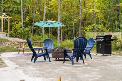 Spacious patio with a fire pit, picnic table, and grill.
