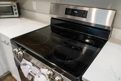This is a stainless steel electric range with a smooth glass cooktop, featuring multiple burners and a digital control panel — ideal for cooking meals with ease and style.