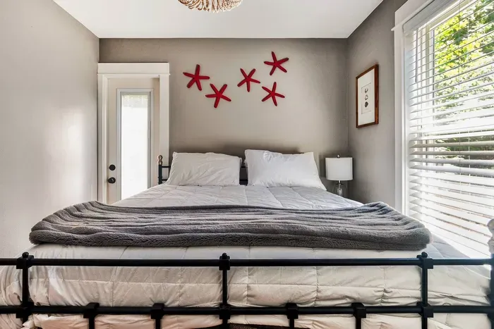 Luxury queen bed with bedside USB chargers and direct patio access, making it a dream couples retreat in Pacific Beach, WA.