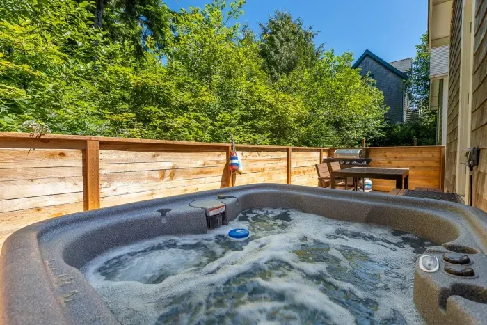 Private 4-person hot tub at our Pacific Beach vacation rental, featuring a quiet backdrop of PNW trees.