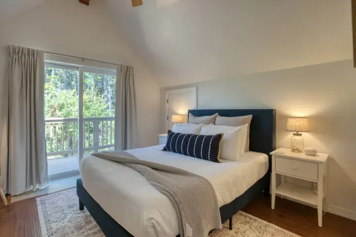 Wake up to natural light in the spacious main bedroom. Featuring a comfortable queen bed, vaulted ceilings, and a large sliding glass door that leads right out to the balcony for a breath of fresh coastal air and to listen to the ocean.