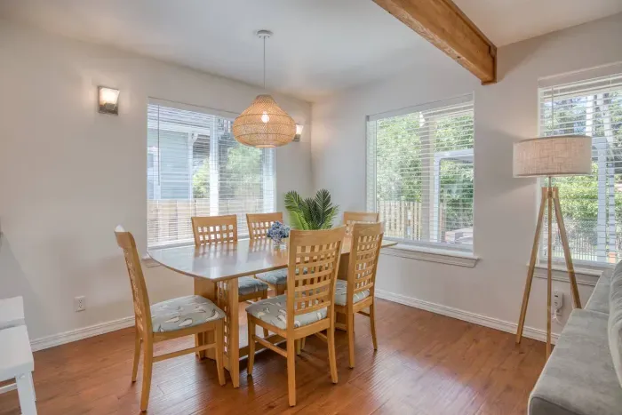 Enjoy home-cooked meals together at our spacious dining table, which comfortably seats six. This bright space features warm wood accents and large windows looking out toward the back patio.