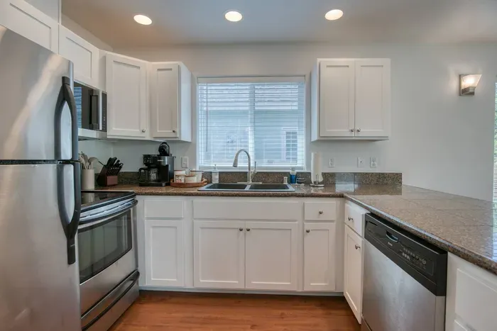 The heart of the cottage! Enjoy a completely stocked kitchen featuring a microwave, dishwasher, coffee maker, and plenty of prep space just off the living area.