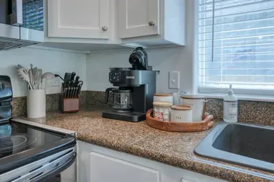 Fuel your beach mornings! Our dedicated coffee station features a versatile Keurig K-Duo maker for single cups or full carafes, complete with mugs and matching canisters stocked with everything you need for the perfect brew