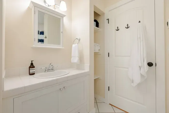 Sparkling clean bathroom with a modern vanity, hairdryer, and fresh towels for your coastal stay.