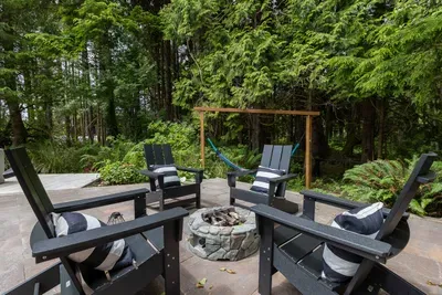 Private fenced patio with gas fire pit and Adirondack chairs