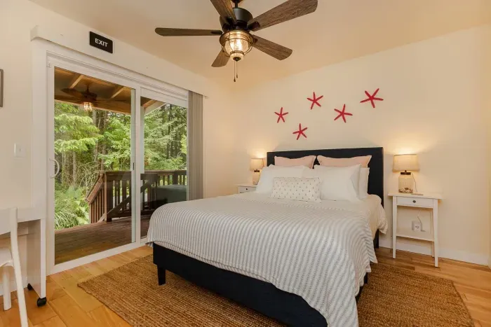 The main bedroom overlooks the wooded backyard with access to the rear deck and hot tub.