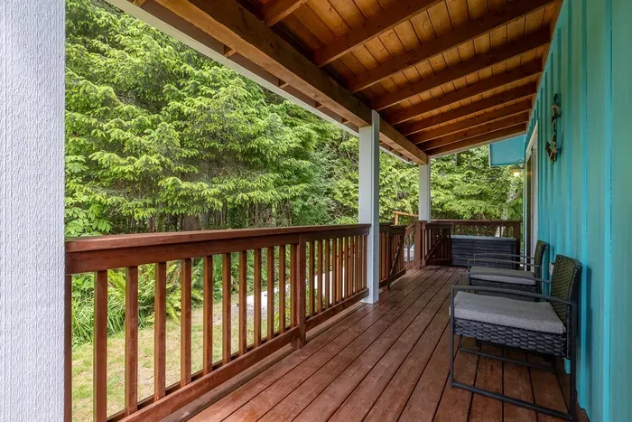 Enjoy a drink on the covered back deck surrounded by the trees