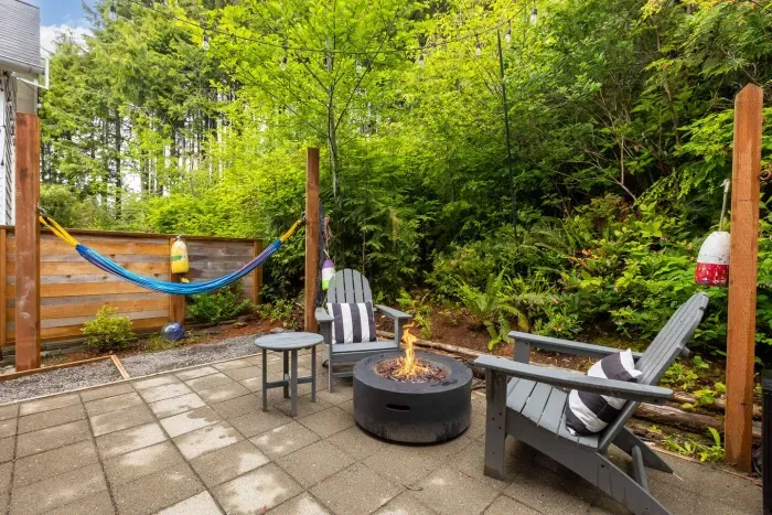 Private patio with hot tub, fire pit, and hammock in a wooded Seabrook setting.