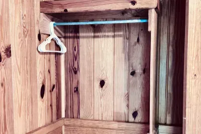 Closet with hangers and extra quilt in bedroom 3