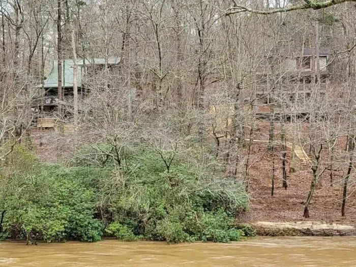 View of both cabins from across the river