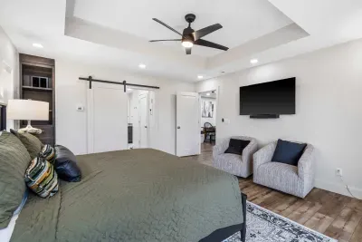 The primary king suite boasts a luxe private ensuite, deck access, & smart TV